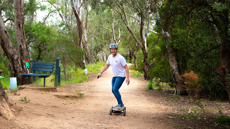 riding Motorized E-Skateboard on dirt trail